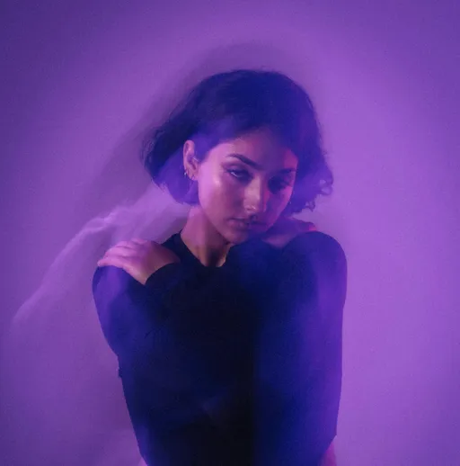 Picture of colorful purple aura waves radiating around a pensive-looking woman